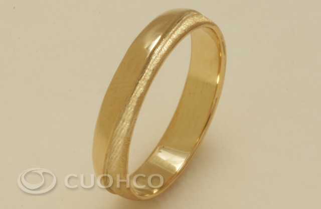 Gold wedding ring with a curved strip in relief in gloss finish over matt background