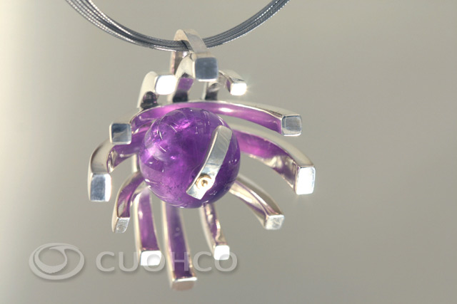 Sterling silver pendant with an amethyst surrounded by an asymmetric halo and with a movable hour hand set by a gold pin