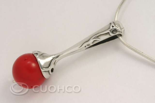 Sterling silver pendant decorated with reliefs and a red coral sphere
