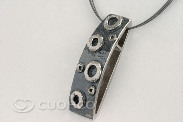 Sterling silver pendant with shapes and textures that simulate lunar craters