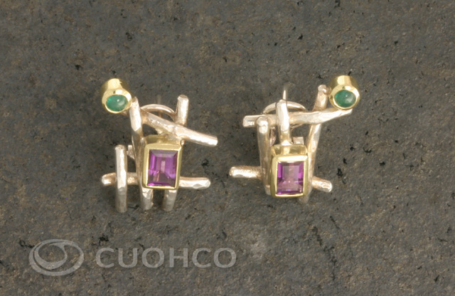 Sterling silver earrings with the shape of an asymmetric grid on which are set an emerald and an amethyst with gold bezels
